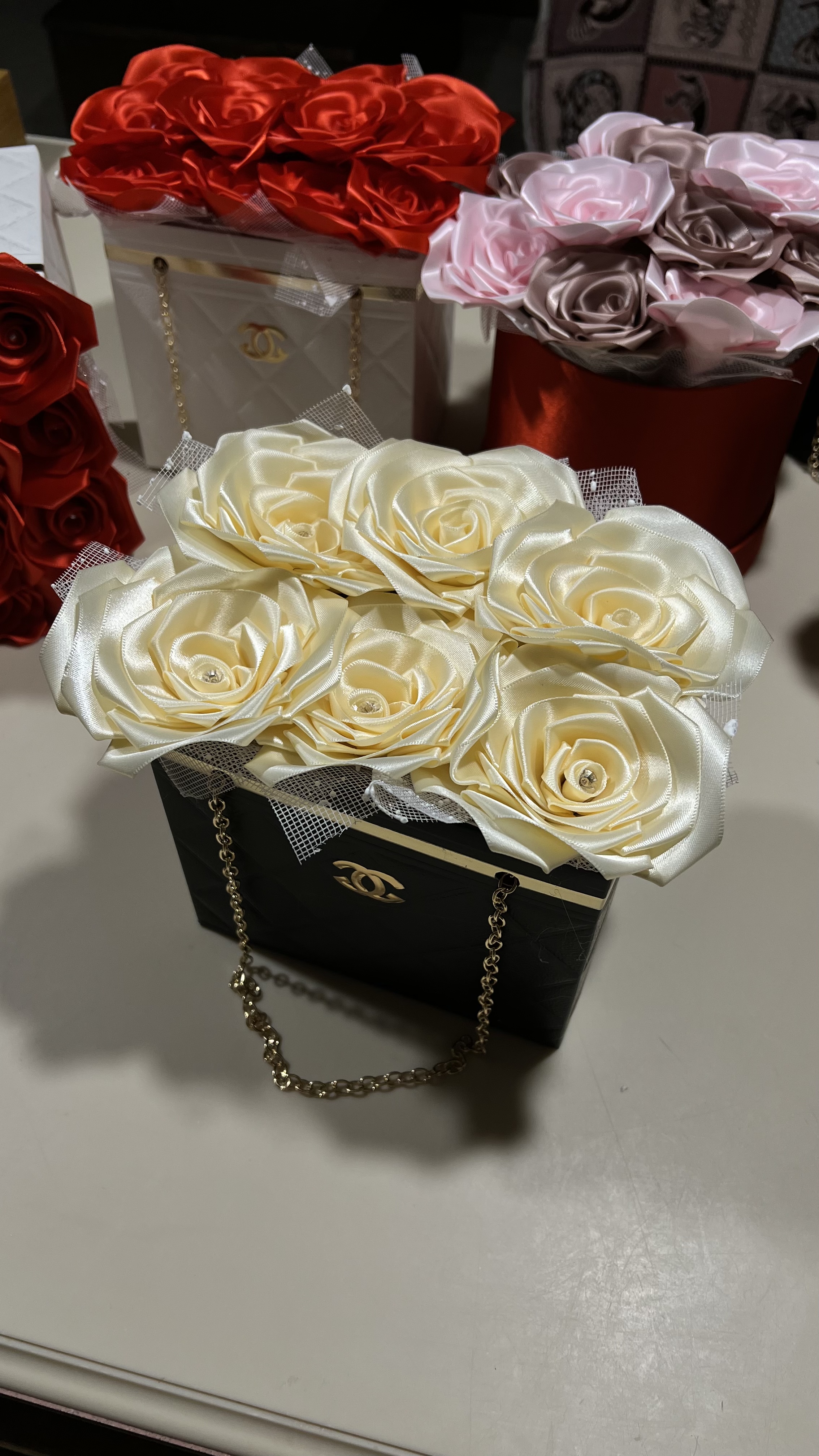 Ivory satin ribbon roses in a black designer gift box with gold chain